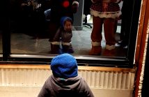 Young Everett Yang, 2, was enthralled by the gingerbread people in the Coldwell Banker Thompson window prior to the parade