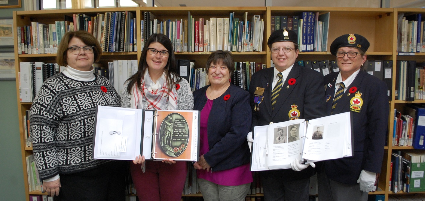Carol Stevens (centre) presents binders filled with local WWII veterans to the Legion and Huntsville Public Library