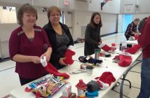 (From left) Karen Dorey, Heather Potts, and Elizabeth Wallace know that these stockings will put smiles on kids' faces on Christmas morning