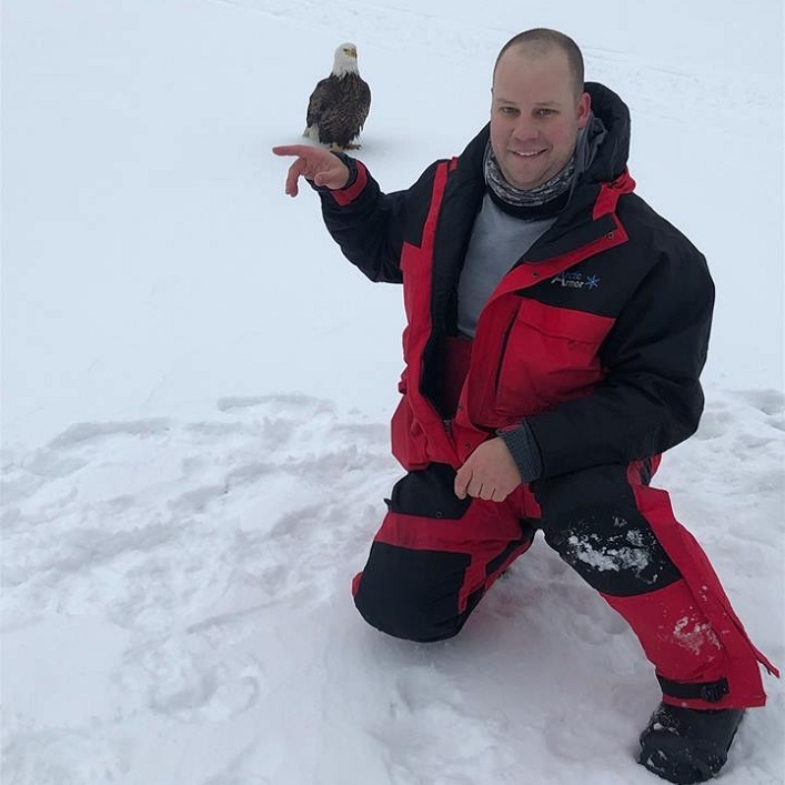 Daniel Storozuk has some fun posing near a bald eagle on Peninsula Lake (Photo courtesy of Sara and Daniel Storozuk)
