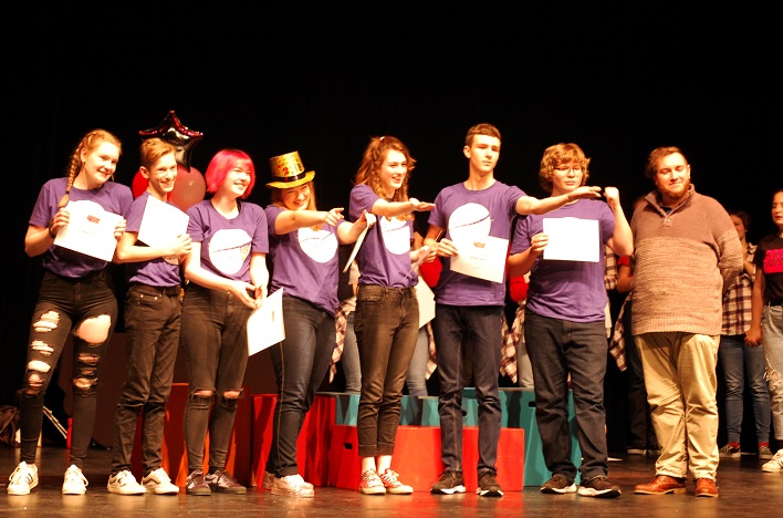 HHS Startdust (from left) Sarah-Emily Waller, Jacob Hunter, Megan Maynard, Aria Platts-Boyle, Emma Flaxman, Oliver Byl, and Max Hill receive their third-place certificates from Canadian Improv Games judge A.J. Comeau (right)
