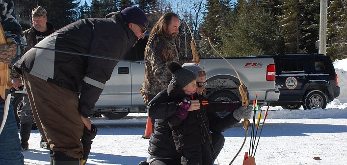 Izzy (foreground) and Jenny Smith try their hand at archery at the 49th annual Dwight Winter Carnival