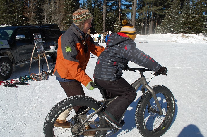 Jamie Honderich aka Hondo of Find Your Wild helps a young rider get started on a fatbike provided by Algonquin Outfitters