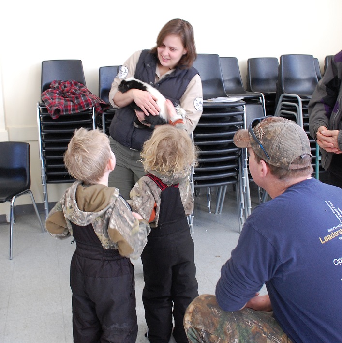 Krystal Hewitt with Speaking of wildlife holds Chanel the skunk so Winter Holtby can give her a pat while Finn (left) and Fred Holtby wait their turn