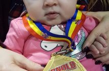 Ayla shows off one of her dad's gold medals (supplied)