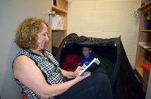 Sharon is reading a series of books to nine-year-old Cain, who literally curls up in a special tent and hangs off every word. She has created a unique bond with him through reading.