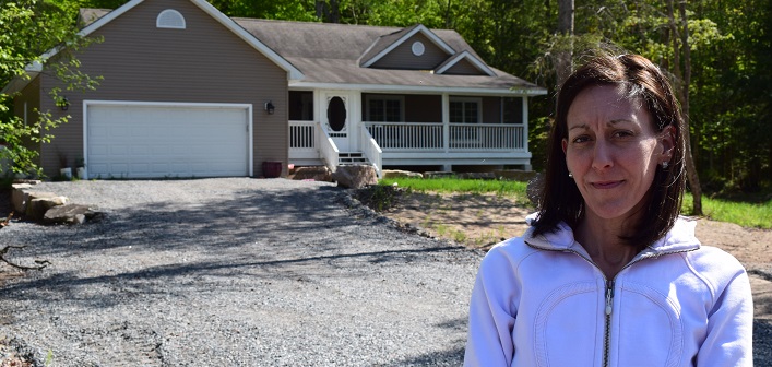Bridget Austin in front of the home her family bought, not knowing it was toxic