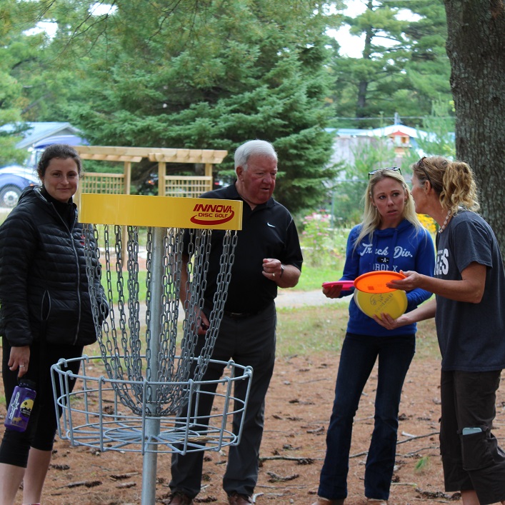 Sarah Roberts (right) of Irwin's Parent Council talks disc golf with school board trustee Bruce Reain (second from left) and Parent Council members Nancy Grant (left) and Nicole Bradley