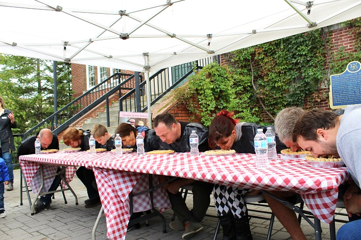 The pie-eating contestants dig in (from left) Adam Brown from The Mill on Main, Robert Watson, six-year-old Connor Crewson, Kathy Bourbonnais, Kyle Carlos, busker Jody Wright, Brent Finn, and 105.5 Moose FM morning show host Brock Cunningham
