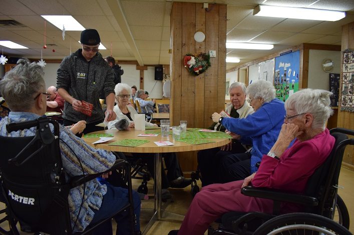 A group of seniors at Fairvern Nursing Home read their Christmas cards, which were hand delivered by students from Huntsville High School (Mandi Hargrave)