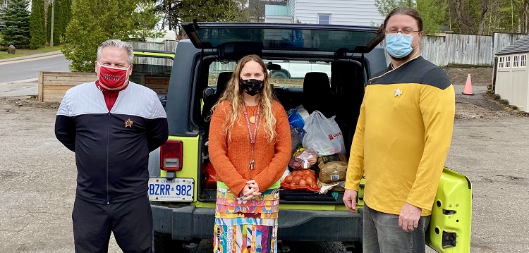 Rob Ehl (left) and Randy Mitson (right) deliver donated food to Heather Cassie at The Table (submitted photo)