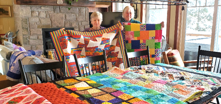 Mary Spring (left) and Terri Howell with just some of the quilts and blankets made by local volunteers (Dawn Huddlestone)
