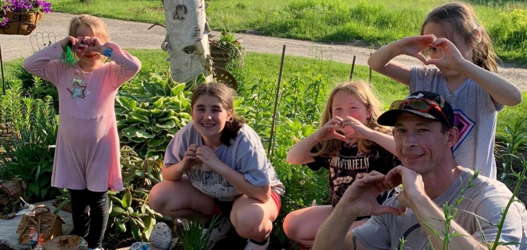 Sophie, Hailey, Nicole, Amelia, and their dad Greg Mason, beside the memorial garden the family built. (supplied)